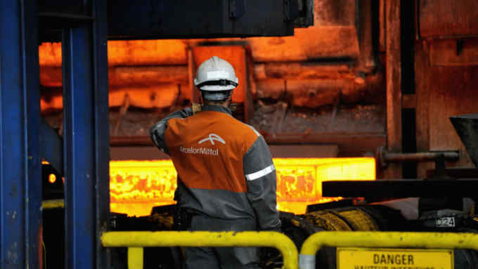 An employee looks at hot steel at the ArcelorMittal steel plant of Grande-Synthe, Northern France, on April 22, 2013. AFP PHOTO PHILIPPE HUGUEN (Photo credit should read PHILIPPE HUGUEN/AFP/Getty Images)
