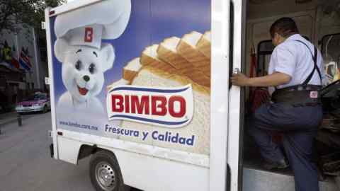 A deliveryman for Grupo Bimbo SAB climbs into his truck in Mexico City, Mexico, on Tuesday, March 31, 2015. Grupo Bimbo SAB's profit outlook is dimming the most among global food-maker peers as competition grows in the U.S., signaling the end of its stock-market out-performance. Photographer: Susana Gonzalez/Bloomberg