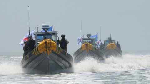 In this photo provided by the South Korean Defense Ministry, South Korean marines and navy soldiers on boats conduct a crackdown against China's illegal fishing in neutral waters around Ganghwa island, South Korea, Friday, June 10, 2016. South Korean military vessels started an operation Friday to repel Chinese fishing boats illegally harvesting prized blue crabs from an area near Seoul's disputed sea boundary with North Korea. (The South Korean Defense Ministry via AP)