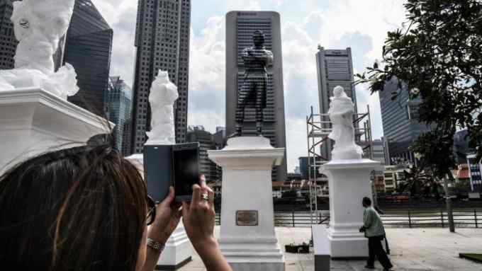 TOPSHOT - The statue of Sir Stamford Raffles (C) is painted on one side to blend into the background building to commemorate the Singapore Bicentennial marking the 200th anniversary of the British arriving in Singapore on January 3, 2019. (Photo by ROSLAN RAHMAN / AFP) / RESTRICTED TO EDITORIAL USE - MANDATORY MENTION OF THE ARTIST UPON PUBLICATION - TO ILLUSTRATE THE EVENT AS SPECIFIED IN THE CAPTION (Photo credit should read ROSLAN RAHMAN/AFP/Getty Images)