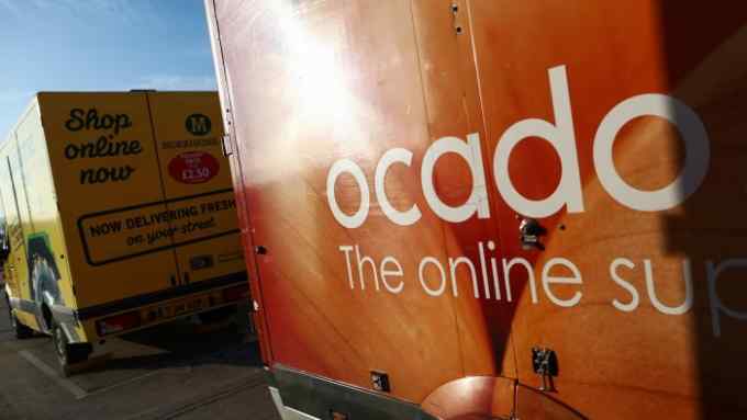 An Ocado branded customer delivery vehicle stands next to Wm Morrisons Supermarkets Plc delivery vehicle outside the Ocado Group Plc distribution centre in Dordon, U.K., on Friday, Dec. 16, 2016. Ocado provides home delivery of a wide range of products including food and drink, toiletries and baby, household, pet care, and holiday products. Photographer: Chris Ratcliffe/Bloomberg