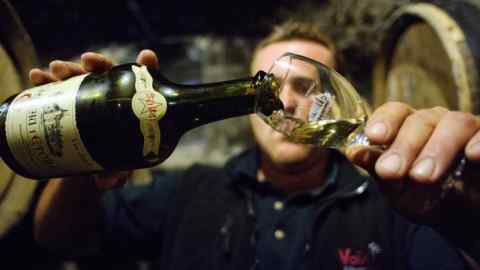 Alexandre Vandelle, owner of the Chateau l'Etoile vineyard pours wine from a 2004 vintage in the cellar of his vineyard on October 8, 2013 in l'Etoile. AFP PHOTO/ SEBASTIEN BOZON (Photo credit should read SEBASTIEN BOZON/AFP/Getty Images)