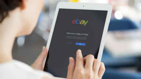 KIEV, UKRAINE - MAY 21, 2014: Woman holding a white Apple iPad Air with eBay welcome message on a screen. eBay is the worldwide online auction and shopping website that founded in September 3, 1995.