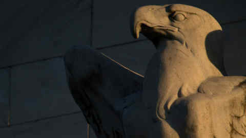 An eagle sculpture stands on the facade of the Marriner S. Eccles Federal Reserve building in Washington, D.C., U.S., on Tuesday, Sept. 15, 2015. While economists are almost equally divided on whether Federal Reserve chair Janet Yellen will raise U.S. interest rates this week, the bond market suggests policy makers will wait. Photographer: Andrew Harrer/Bloomberg