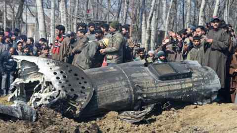 UPDATING CAPTION Indian soldiers and Kashmiri onlookers stand near the remains of an Indian Air Force helicopter after it crashed in Budgam district, on the outskirts of Srinagar on February 27, 2019. - Officials said an investigation was underway into the cause of the crash, which came as Pakistan claimed to have shot down two Indian fighter jets in the divided and disputed Kashmir region. (Photo by Tauseef MUSTAFA / AFP) / UPDATING CAPTIONTAUSEEF MUSTAFA/AFP/Getty Images