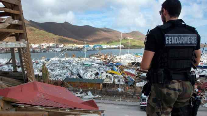 A gendarme stands in front of smashed boats on September 16, 2017 at Marigot shipyard on the French Caribbean island of Saint Martin after the island was hit by Hurricane Irma. The Caribbean island of St Martin was a place of spectacular inequalities before Hurricane Irma flattened rich and poor neighbourhoods alike -- but some residents now dream of a fresh start. Ten days after the storm devastated the island, cleaning up and reconstruction remain a priority for St Martin, although repairing roads and buildings before the high season, which usually starts in November and runs until April, seems nearly impossible. / AFP PHOTO / Helene Valenzuela (Photo credit should read HELENE VALENZUELA/AFP/Getty Images)