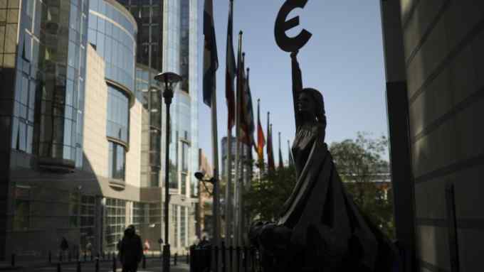 People walk past a sculpture with the Euro currency logo outside the European Parliament building in Brussels, Wednesday, May 15, 2019. Europeans from 28 countries will head to the polls May 23-26 to choose lawmakers to represent them at the European Parliament for the next five years. (AP Photo/Francisco Seco)