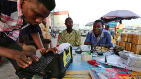 Africa's Biggest Phone Operators MTN Group Ltd. As They Face $5.2 Billion Fine...A man enters a customer's mobile phone sim card details on an MTN Group Ltd. registration machine at a roadside kiosk in Lagos, Nigeria, on Saturday, Oct. 31, 2015. MTN, Africa's largest wireless operator, remains in negotiations with Nigerian regulators over a $5.2 billion fine for failing to comply with an order to disconnect customers with unregistered phone cards, according to a person familiar with the matter. Photographer: George Osodi/Bloomberg