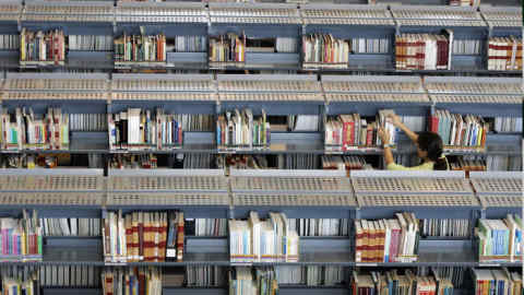 A visitor checks through a shelf for books at the newly built Singapore's National Library