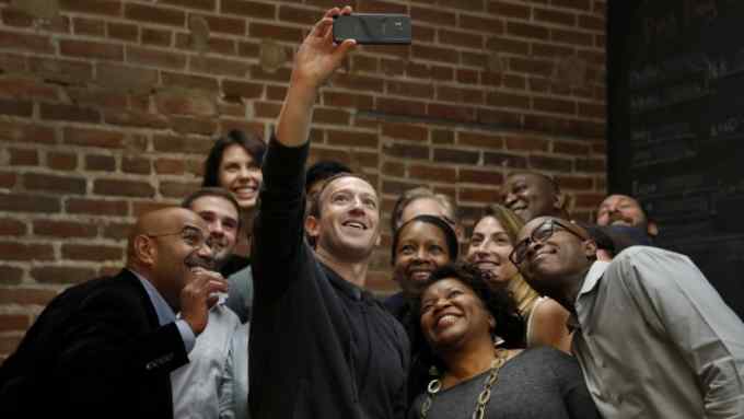 Facebook CEO Mark Zuckerberg takes a selfie with a group of entrepreneurs and innovators after taking part in a roundtable discussion at Cortex Innovation Community technology hub, Thursday, Nov. 9, 2017, in St. Louis. Zuckerberg was in St. Louis to announce a program to boost small businesses and bolster individual technical skills both on and off Facebook. (AP Photo/Jeff Roberson)