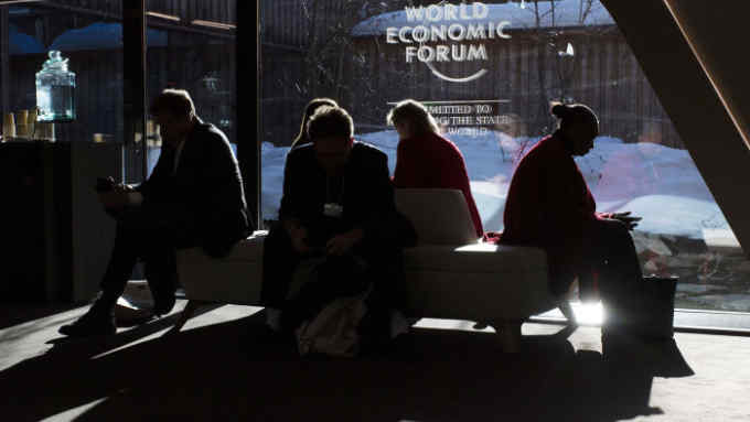 Mandatory Credit: Photo by GIAN EHRENZELLER/EPA-EFE/Shutterstock (10536750dw) Participants take a break under the Logo of the WEF, during the 50th annual meeting of the World Economic Forum (WEF) in Davos, Switzerland, 23 January 2020. The meeting brings together entrepreneurs, scientists, corporate and political leaders in Davos under the topic 'Stakeholders for a Cohesive and Sustainable World' from 21 to 24 January 2020. 50th annual meeting of the World Economic Forum in Davos, Switzerland - 23 Jan 2020