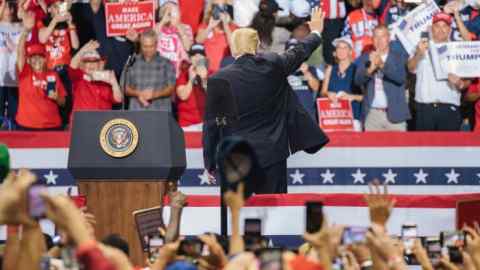U.S. President Donald Trump waves during a campaign rally for Representative Ron DeSantis, Republican candidate for governor of Florida, not pictured, in Estero, Florida, U.S., on Wednesday, Oct. 31, 2018. Trump doubled down on his vow to deny U.S. citizenship to children born of unauthorized immigrants as he kicked off an eleventh-hour effort to save Republican control of the Senate. Photographer: Jayme Gershen/Bloomberg