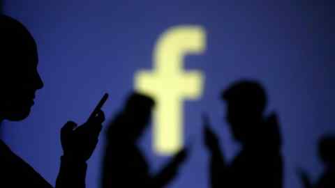 REFILE - CLARIFYING CAPTION Silhouettes of mobile users are seen next to a screen projection of Facebook logo in this picture illustration taken March 28, 2018.  REUTERS/Dado Ruvic/Illustration