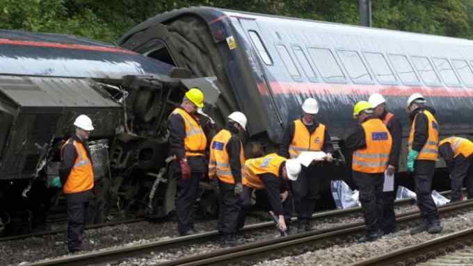 Rail crash investigators pick their way through the wreckage of the Hatfield train crash as they carefully searched for clues to the cause of the disaster which killed four people and injured dozens more. * The wreckage included a set of four train wheels that had been ripped from under the buffet car as it toppled over at a speed of about 110mph.