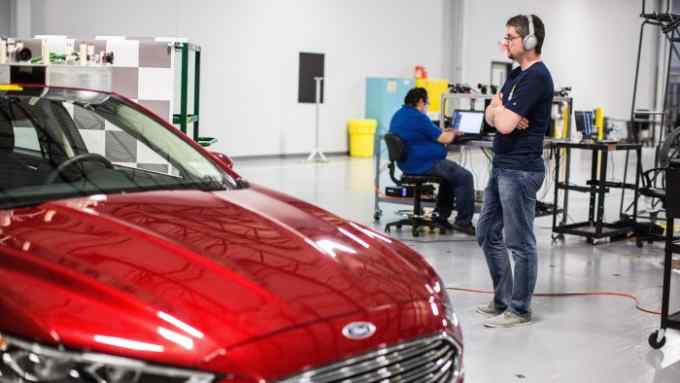 Test fleet: Argo AI staff inspect driverless car sensors.
