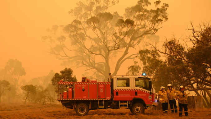 TOPSHOT - Firefighters protect a property from bushfires burning near the town of Bumbalong south of Canberra on February 1, 2020. - Authorities in Canberra on January 31, 2020 declared the first state of emergency in almost two decades as a bushfire bore down on the Australian capital. (Photo by PETER PARKS / AFP) (Photo by PETER PARKS/AFP via Getty Images)