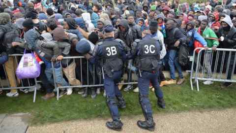 French police officers push back a large crowd of migrants as they line-up at a processing centre in &quot;the jungle&quot; near Calais, northern France, as the mass exodus from the migrant camp begins. PRESS ASSOCIATION Photo. Picture date: Monday October 24, 2016. Police vans and fire engines had gathered on the perimeter of the rat-infested slum as migrants and refugees queued in the dark to register for accommodation centres elsewhere in France after being told they must leave the camp or risk arrest and deportation. See PA story POLITICS Calais. Photo credit should read: John Stillwell/PA Wire