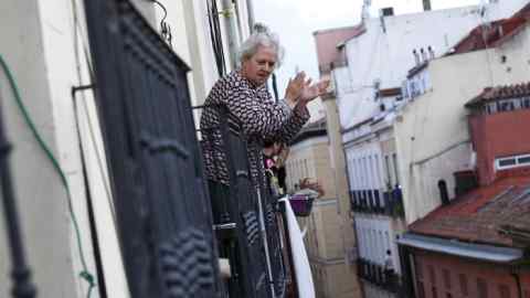 MADRID, SPAIN - APRIL 18: A woman on her balcony is seen applauding to pay tribute to healthcare workers struggling to fight the coronavirus pandemic on on April 18, 2020 in Madrid, Spain. Spain is beginning to ease strict lockdown measures to ease its economy, people in some services including manufacturing, construction are being allowed to return to work but must adhere to strict safety guidelines. More than 20,100 people are reported to have died in Spain due to the COVID-19 outbreak, although the country has reported a decline in the daily number of deaths. (Photo by Carlos Alvarez/Getty Images)