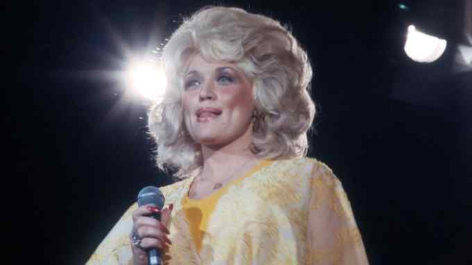 LOS ANGELES - CIRCA 1975: Country singer Dolly Parton performs onstage wearing a yellow dress in circa 1975 in Los Angeles, California. (Photo by Michael Ochs Archives/Getty Images)