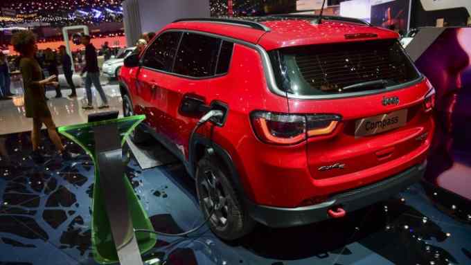 A charging cable sits attached to a Jeep Compass sport utility vehicle (SUV) plugin hybrid automobile on the Fiat Chrysler Automobiles NV exhibition stand on day two of the 89th Geneva International Motor Show in Geneva, Switzerland, on Wednesday, March 6, 2019. The show near Lake Leman, which opens to the public from March 7 to 17, will be the first gilded showcase of the year for the likes of Bugatti, Koenigsegg, Lamborghini, and Pininfarina, among others. Photographer: Chris J. Ratcliffe/Bloomberg