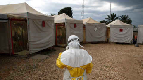 FILE PHOTO: A health worker wearing Ebola protection gear, walks before entering the Biosecure Emergency Care Unit (CUBE) at the ALIMA (The Alliance for International Medical Action) Ebola treatment centre in Beni, in the Democratic Republic of Congo, March 30, 2019. REUTERS/Baz Ratner/File Photo