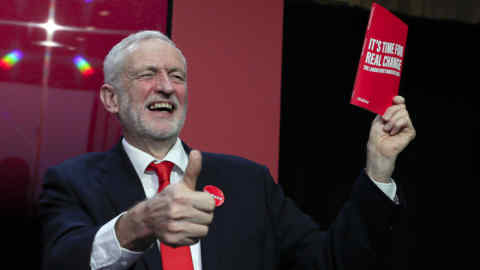 Jeremy Corbyn, Leader of Britain's opposition Labour Party, gives a thumbs up holding a copy of the manifesto on stage at the launch of Labour's General Election manifesto, at Birmingham City University, England, Thursday, Nov. 21, 2019. Britain goes to the polls on Dec. 12. (AP Photo/Kirsty Wigglesworth)