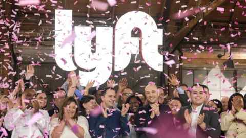 FILE- In this March 29, 2019, file photo Lyft co-founders John Zimmer, front third from left, and Logan Green, front third from right, cheer as they as they ring a ceremonial opening bell in Los Angeles. Lyft gave investors a lesson in how quickly a company‚Äôs market value can change. The ride-hailing company‚Äôs stock surged more than 20% from its IPO price on Friday. But by the first hour of Lyft‚Äôs second day of trading, the stock had fallen below the IPO price of $72. (AP Photo/Ringo H.W. Chiu, File)