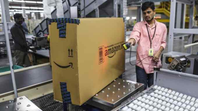 An employee scans the bar code of a package at the Amazon.com Inc. fulfillment center in Hyderabad, India on Thursday, Sept. 7, 2017. Amazon opened its largest Indian fulfillment center in Hyderabad. The center spans 400,000 square feet with 2.1m cubic feet of storage capacity the company said in a statement. Photographer: Dhiraj Singh/Bloomberg