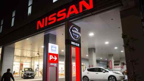 A pedestrian walks past a Nissan Motor Co. dealership at night in Yokohama, Japan, on Monday, Dec. 3, 2018. Nissan's independent board members met on Nov. 4 to select Carlos Ghosn's successor as chairman, with their choice to replace the arrested car titan an indicator of the direction the automaker will likely take in its alliance with Renault SA. Photographer: Tomohiro Ohsumi/Bloomberg