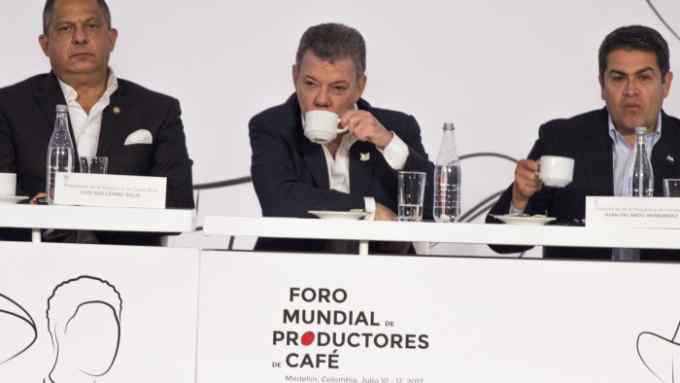 Juan Manuel Santos, Colombia's president (C) and Juan Orlando Hernandez, Honduras' president (L) takes some coffee, during the World Coffee Producers Forum in Medellin, Colombia, on Tuesday, July 11, 2017.  (Photo by Daniel Garzon Herazo/NurPhoto via Getty Images)