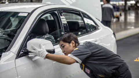 An employee makes final checks on a VinFast Lux A 2.0 sedan as it moves through the final inspection area of the assembly line at the automaker's plant in Haiphong, Vietnam, on Friday, June 14, 2019. Real-estate conglomerate Vingroup JSC’s auto unit VinFast marked the rollout of its first vehicles from its assembly line on Friday, embodying the aspirations of the fast-developing country’s government to build a modern manufacturing sector. Photographer: Yen Duong/Bloomberg