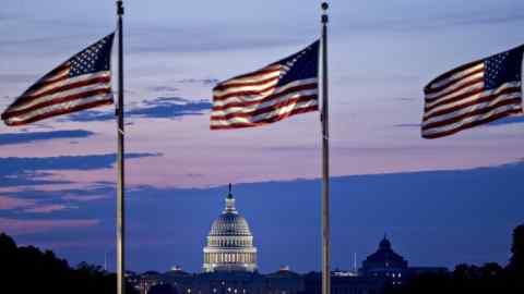 The U.S. Capitol building stands past American flags before sunrise in Washington, D.C., U.S., on Tuesday, July 11, 2017. As Congress returned from its mid-summer break yesterday for a crucial three-week stretch, several obstacles await lawmakers, including an ongoing health-care fight, divisions among Republicans on the basic parameters of a tax bill, and a maelstrom of upcoming deadlines to keep the government running and avert a catastrophic default on U.S. debt. Photographer: Andrew Harrer/Bloomberg