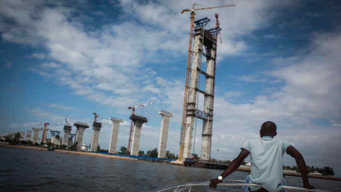 A man rides a boat near the Catembe side of the construction site of the Maputo-Catembe Bridge, which will be the longest suspension bridge in Africa once completed, in Catembe on February 10, 2017. / AFP PHOTO / JOHN WESSELS        (Photo credit should read JOHN WESSELS/AFP/Getty Images)