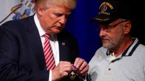 Republican U.S. Presidential nominee Donald Trump talks to Lt. Col. Louis Dorfman, who gave Trump his Purple Heart, during a campaign event at Briar Woods High School in Ashburn, Virginia, U.S. August 2, 2016. REUTERS/Eric Thayer