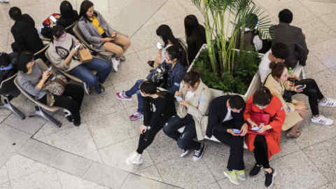 People use smartphones as they sit at the Oriental Pearl Tower in Shanghai, China, on Friday, Oct. 13, 2017. A number of economic indicators show &quot;stabilized and stronger growth&quot; and the momentum of a 6.9 percent expansion in the first six months of 2017 &quot;may continue in the second half,&quot; People’s Bank of China Governor Zhou Xiaochuan said. Photographer: Qilai Shen/Bloomberg