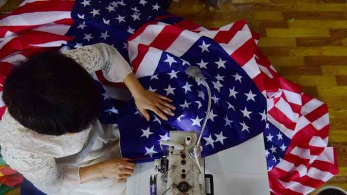 This photo taken on July 13, 2018 shows a Chinese employee sewing a US flag at a factory in Fuyang in China's eastern Anhui province.
As the Sino-US trade war rages, a factory set amid corn and mulberry fields in central China stitches together US and &quot;Trump 2020&quot; flags -- and business is good. / AFP PHOTO / - / China OUT-/AFP/Getty Images