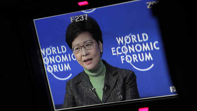Hong Kong Chief Executive Carrie Lam is seen on a monitor she takes part in a panel discussion at the World Economic Forum in Davos, Switzerland, Wednesday, Jan. 22, 2020. A preliminary test on a traveller from Wuhan China shows a positive result on the coronavirus in Hong Kong. (AP Photo/Markus Schreiber)