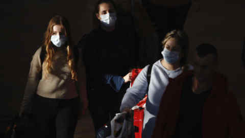 Travelers wearing protective masks arrive at the Ben Gurion Airport, near Tel Aviv, Israel, Thursday, Feb. 27, 2020. (AP Photo/Ariel Schalit)