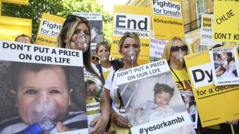 epa06051367 Campaigners wearing oxygen masks hold banners during a protest over the lack of availability of a 'life-saving' cystic fibrosis drug 'Orkambi' in central London, Britain, 26 June 2017. In 2016 the Bristish National Institute for Health and Care Excellence (NICE) rejected the drug Orkambi to be available on the National Health Service (NHS). EPA/FACUNDO ARRIZABALAGA