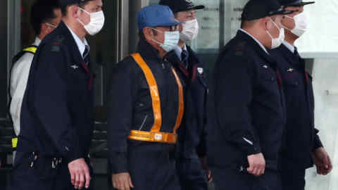 Former Nissan chairman Carlos Ghosn (C-light blue cap) is escorted as he walks out of the Tokyo Detention House following his release on bail in Tokyo on March 6, 2019. - Ghosn posted bail of 1 billion yen (9 million USD) in cash on March 6, paving the way for his release from the Tokyo detention centre after more than three months in custody. (Photo by Behrouz MEHRI / AFP) (Photo credit should read BEHROUZ MEHRI/AFP/Getty Images)