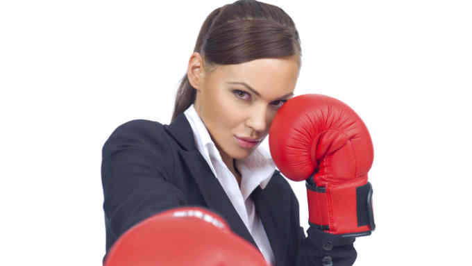 Portrait of beautiful and young business woman wearing boxing gloves