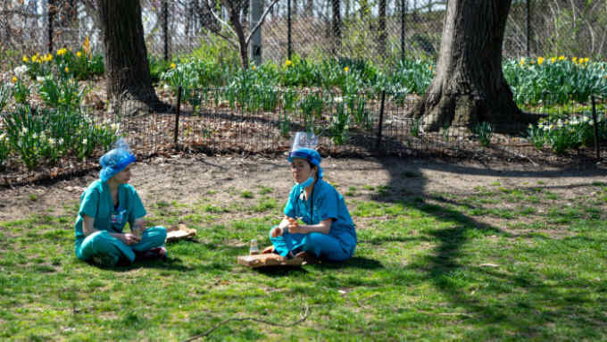 NEW YORK, NY - APRIL 7: Two nurses have lunch on the grass in Central Park across from Mount Sinai hospital on April 7, 2020 in New York City, New York. Gov. Andrew M. Cuomo said on Tuesday in his daily briefing that 731 people had died since the prior day of the virus, the states highest one-day total (Photo by David Dee Delgado/Getty Images)