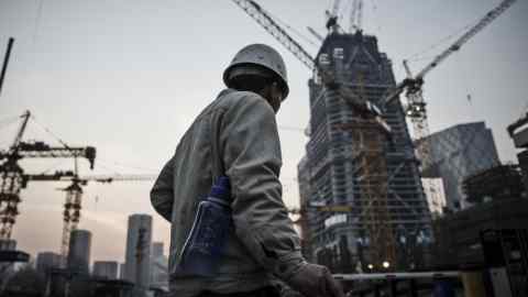 A worker walks past cranes operating on a construction site in Beijing, China, on Wednesday, March 2, 2016. Obscured by the focus on the accuracy of China's growth figures is a tumble in estimates for the economy without adjusting for inflation -- a slide that gives a clearer picture of why the country's slowdown has stoked rising concern about its debt burden. Photographer: Qilai Shen/Bloomberg