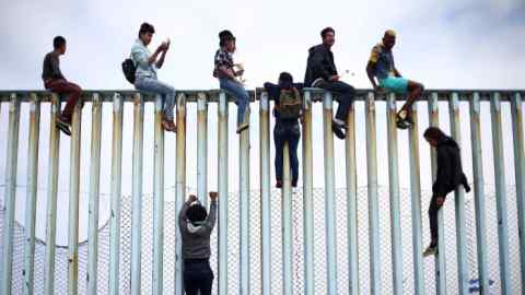 Members of a caravan of migrants from Central America climb up the border fence between Mexico and the U.S., as a part of a demonstration prior to preparations for an asylum request in the U.S., in Tijuana, Mexico April 29, 2018. REUTERS/Edgard Garrido     TPX IMAGES OF THE DAY - RC1D468F1060