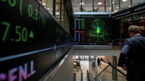 Financial market figures are shown on big screens and a ticker in the main entrance at London Stock Exchange