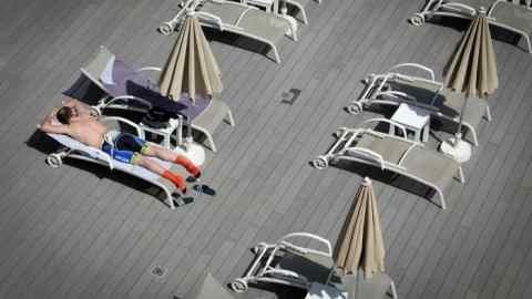 A tourist sunbathes at a hotel in Palma de Mallorca, Spain