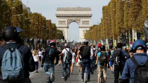 People use monowheel as they enjoy a vehicle-free day in front of the Arc de Triomphe in Paris