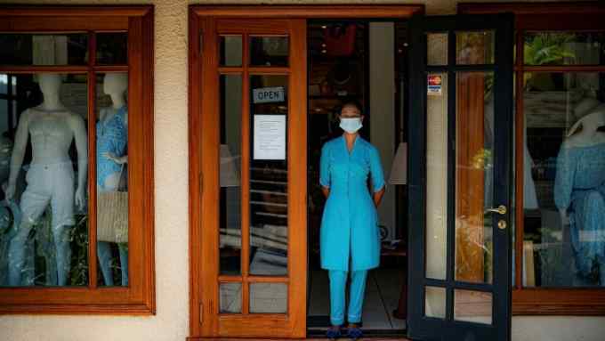 A boutique shop worker, wearing a medical face mask, waits for customers in Mauritius