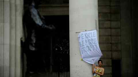 A woman holding a banner in front of the Bank of England during an ‘Occupy London’ protest