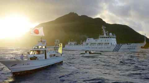 A Chinese maritime surveillance vessel, right, passes near Japan’s Senkaku Islands in the East China Sea